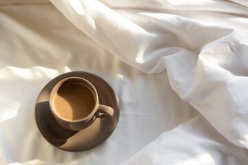 Aromatic morning coffee on bed, above view. Space for text