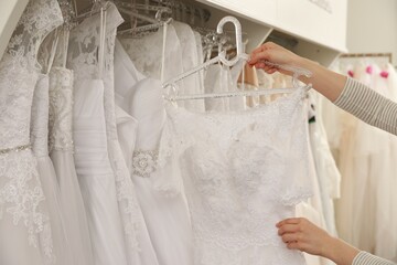 Young woman choosing wedding dress in salon, closeup