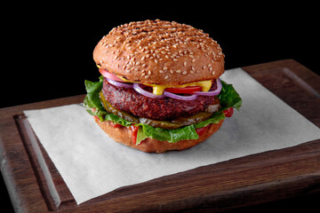 Hamburger with sesame bun, meat cutlet, mustard, tomato, onion, pickled cucumbers and salad