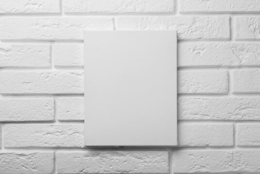 Blank canvas on white brick wall. Space for design