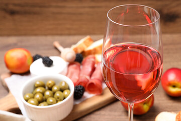 Fototapeta Glass of delicious rose wine and snacks on table, closeup obraz