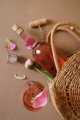 Fototapeta Flat lay composition with rose wine, wicker bag and beautiful pink peonies on brown background obraz