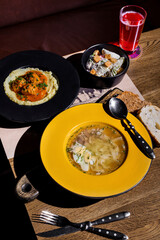 Soup, mashed potatoes, salad and juice in a glass
