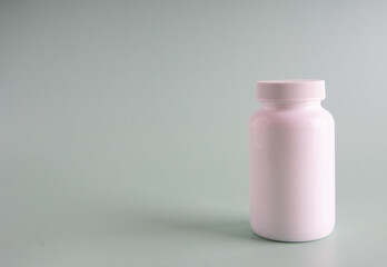 Viral disease prevention concept. Female hand holds jar with vitamins, pills, medicines or drugs on orange background.