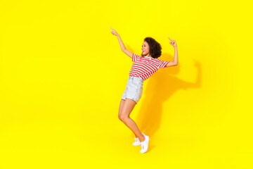 Full length photo of young smiling dancing lady stay toes directing empty space new sale isolated on yellow color background
