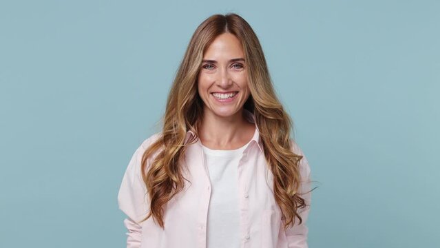 Young smiling happy cool cheerful friendly positive calm caucasian woman 30s wear pink shirt white t-shirt looking camera isolated on plain pastel light blue cyan background People lifestyle concept