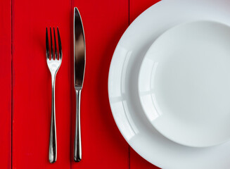 Plate and cutlery on the table. Fork and knife on an empty plate. Close-up image.