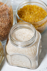 assortment of cereals in glass jars, vertical