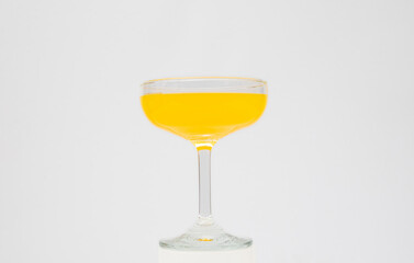 Orange juice in wine glass on white background
