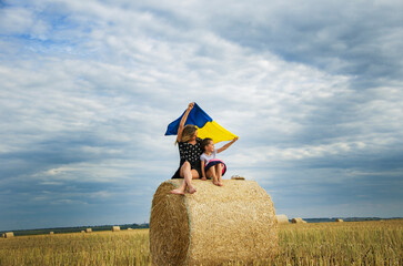 The concept of freedom. Ukrainian flag against the sky in children's hands. Children against war....