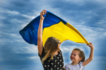 A child with the Ukrainian flag in the field. The concept of freedom. Children against war. War in...