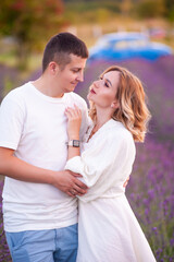 Fototapeta premium Young couple in love bride and groom, wedding day in summer. Enjoy a moment of happiness and love in a lavender field.
