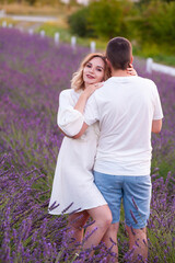 Fototapeta premium Young couple in love bride and groom, wedding day in summer. Enjoy a moment of happiness and love in a lavender field.