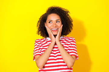 Closeup photo of young attractive lady hold hands cheeks surprised looking interested isolated on yellow color background