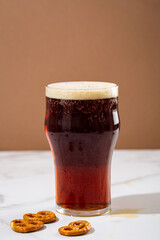 Close up of One glass of brown beer with foam on top  food and drink
