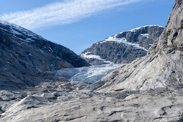 Part of the Nigardsbreen glacier surrounded by high snow-capped mountains.