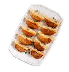 Pan-fried gyoza dumpling jiaozi in a plate isolated on white background.