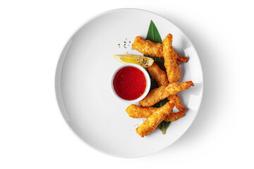 Shrimps in batter with sesame seeds, lemon, sauce in a gravy boat and a leaf