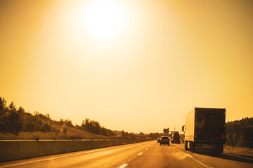 Autobahn mit Lkw und Pkw unter heißer. Sommersonne während einer Hitzewelle