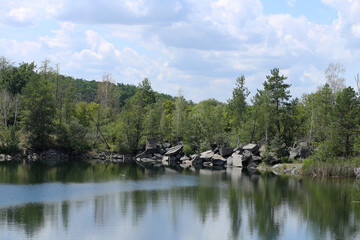 Fototapeta na wymiar A wonderful landscape: a flooded granite quarry, on a summer day.