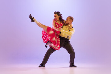 Active and emotional couple in colorful retro style costumes dancing incendiary dances isolated on...