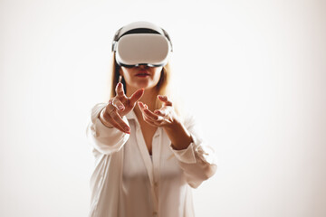 A woman interacts with her virtual reality glasses and tries to touch something with her hand