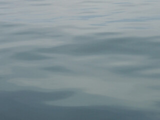 Foggy gray sea surface with dawn colored texture.