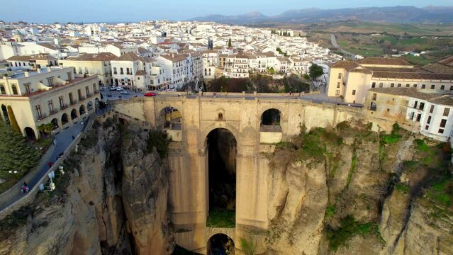 Flying over Ronda and Puente Nuevo Bridge at sunset. Aerial view of medieval town of Ronda, Spain