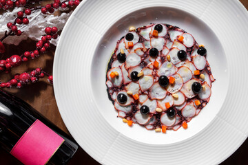 Sliced pieces of octopus with olives, carrots