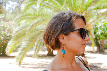 Portrait of beautiful woman with sun glasses in park.