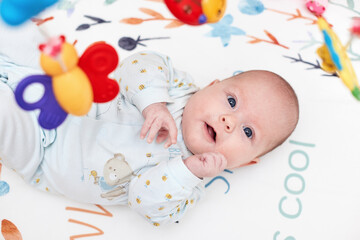 newborn baby in crib with toys at home