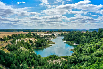 Fototapeta na wymiar Aerial view of a lake in the mining of an open pit for sand and quartz in a forest area in the north of Germany