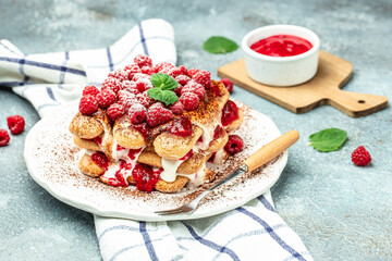 berry tiramisu with biscuit with coffee cream and fresh berries. Tiramisu with raspberry on a light...
