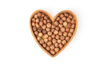 Filbert. Hazelnut in a heart shaped wooden plate isolated on white background. Products for heart health. Copy space.