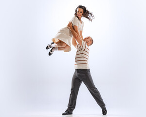 Astonished young dancing man and woman dance sport dances isolated on white background. 50s, 60s...