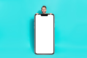 Fototapeta na wymiar Photo of excited funky positive man sale reaction placard empty space wear pullover isolated blue color background