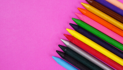 Color pencils on pink background, copy space .