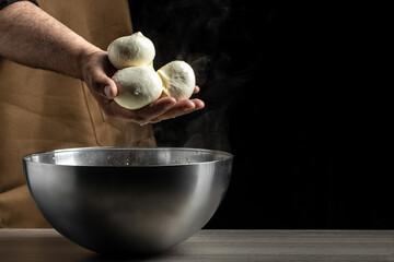 The homemade cheese maker produces handmade mozzarella with fresh bio milk. process of making mozzarella. Italian hard cheese silano or caciocavallo in cheesemaker hands