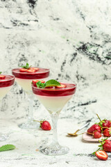 Sweet strawberry mousse with organic yoghurt. Fresh fruit dessert decorated with mint topping with strawberry sauce. Italian dessert, vertical image. top view. place for text