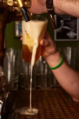 Fototapeta na wymiar Hand bartender pouring large lager beer. Light cold filtered beer in glass beaker.
