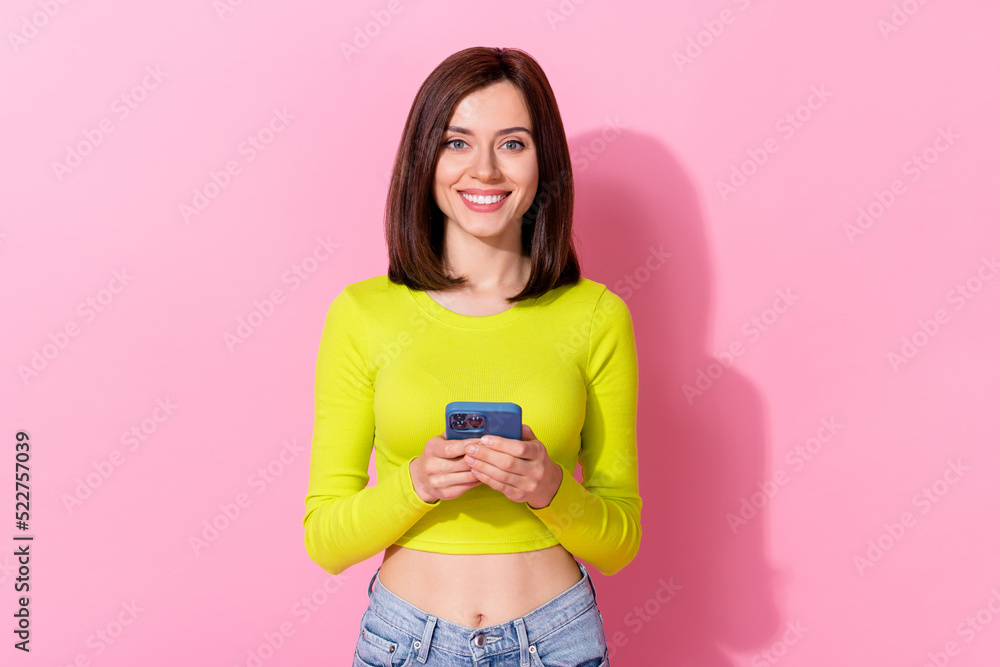 Sticker portrait of cheerful pretty girl hold use telephone chatting texting post isolated on pink color bac