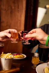 Man and woman drink different liquors in pub. Friends having alcoholic drinks in the bar