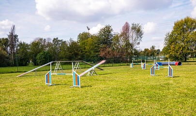Area equipped for dog training. Dog training in a fenced area..Obstacle courses with tunnels, steep ramp, slides, poles and high jump.