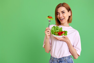 beautiful woman eating fresh vegetable salad on white background