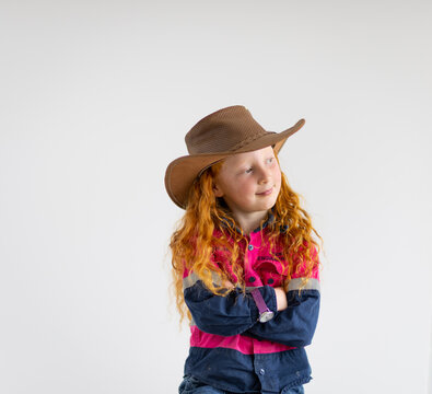 child wearing hi-vis work shirt and cowboy hat with arms crossed