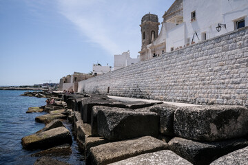 Tourists outside the old port of historical city of Monopoli in summer
