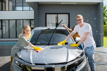 happy family wash and clean an automative car at home garage with water jet and shampoo wax  on weekend