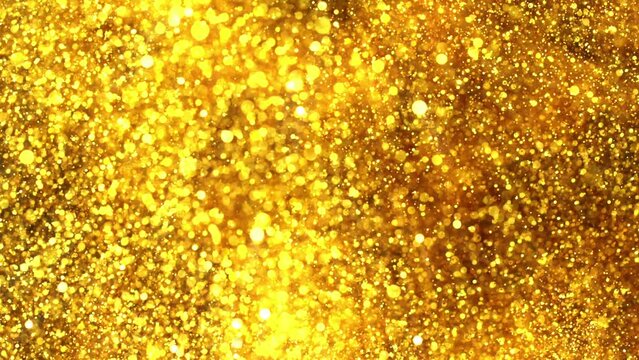 Super slow motion of glittering golden particles on black background. Shallow depth of focus. Abstract shimmering background with glows.