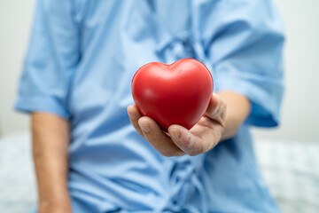 Asian senior or elderly old lady woman patient holding red heart, healthy strong medical concept.