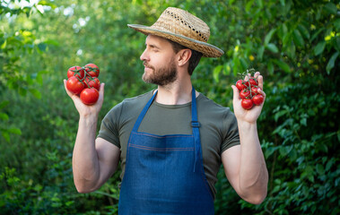 farmer villager in straw hat with tomato bunch